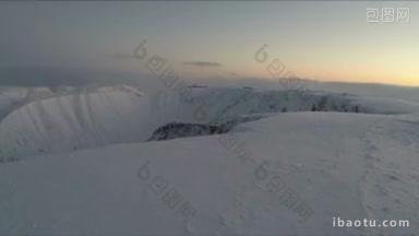 飞越冬季高山景观雪原高原和远处的滑雪场